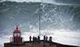 People watch an unidentified surfer ride a big wave at the Praia do Norte, north beach, at the fishing village of Nazare in Portugal's Atlantic coast